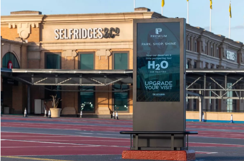 Panneau d'affichage numérique dans le Trafford Centre montrant une publicité de Premium Parking sur le service de valenting des voitures